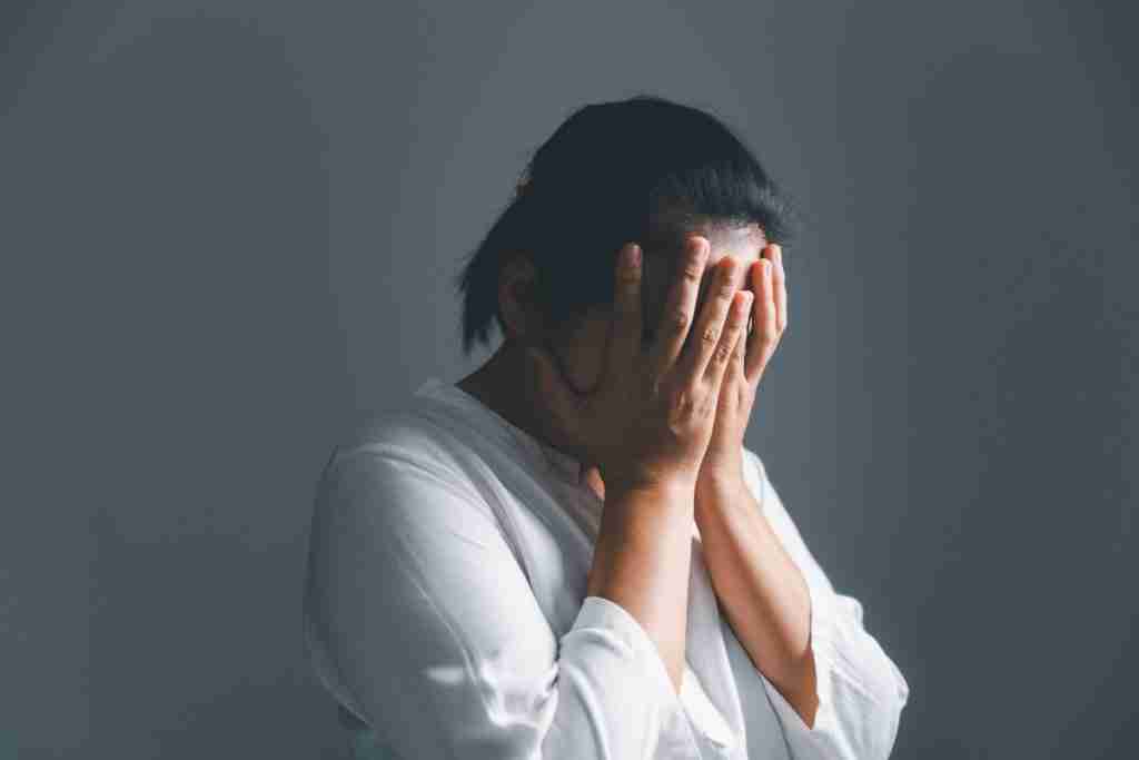 Woman with head in her hands - in distress from an assault - rape crisis in Nigeria 
