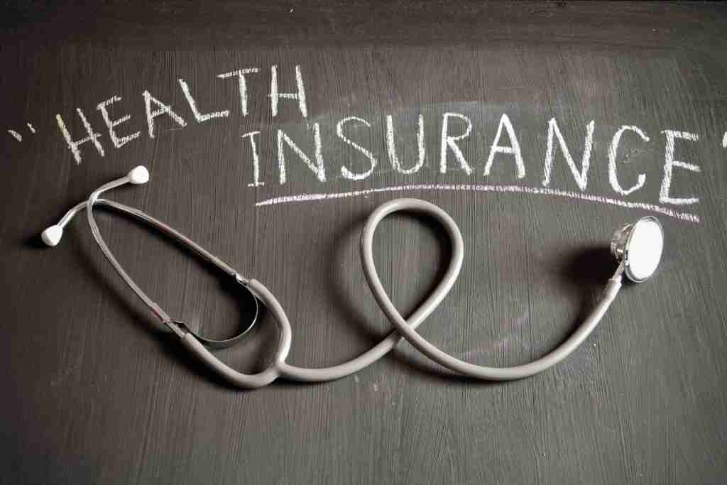 Health Insurance text written on blackboard with stethosope