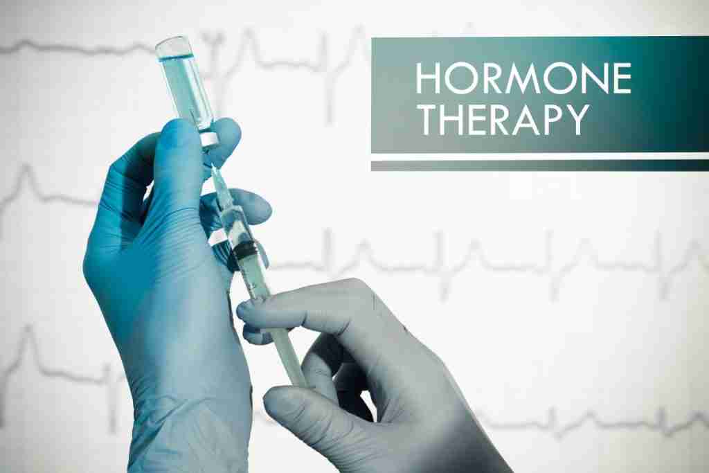 Image of gloved hands holding a syringe that may contain hormones like progesterone or testosterone - breast cancer risks addressed