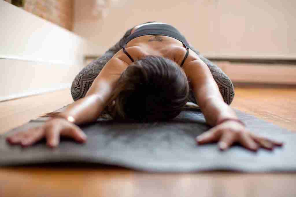 Yoga for managing fibroid symptoms - black lady in childs pose