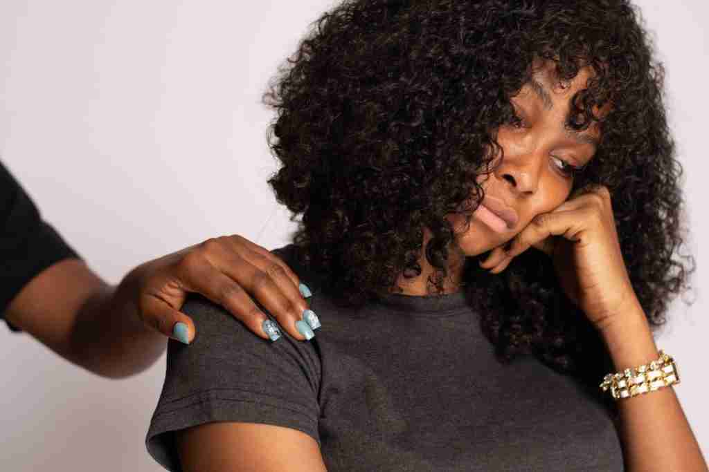 Lady looking sad with hand holding up her face - embarrassing symptoms of menopause.