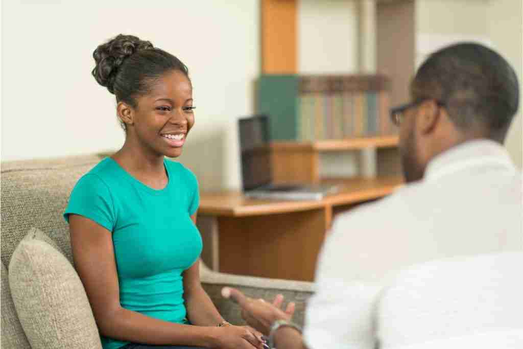 Young black lady smiling as she speaks to a counsellor - Therapies for Powerful Self-Care