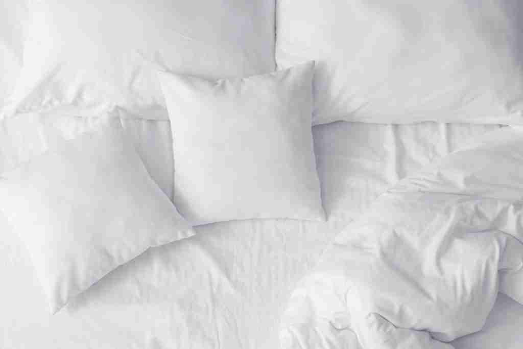 white pillows scattered on the bed