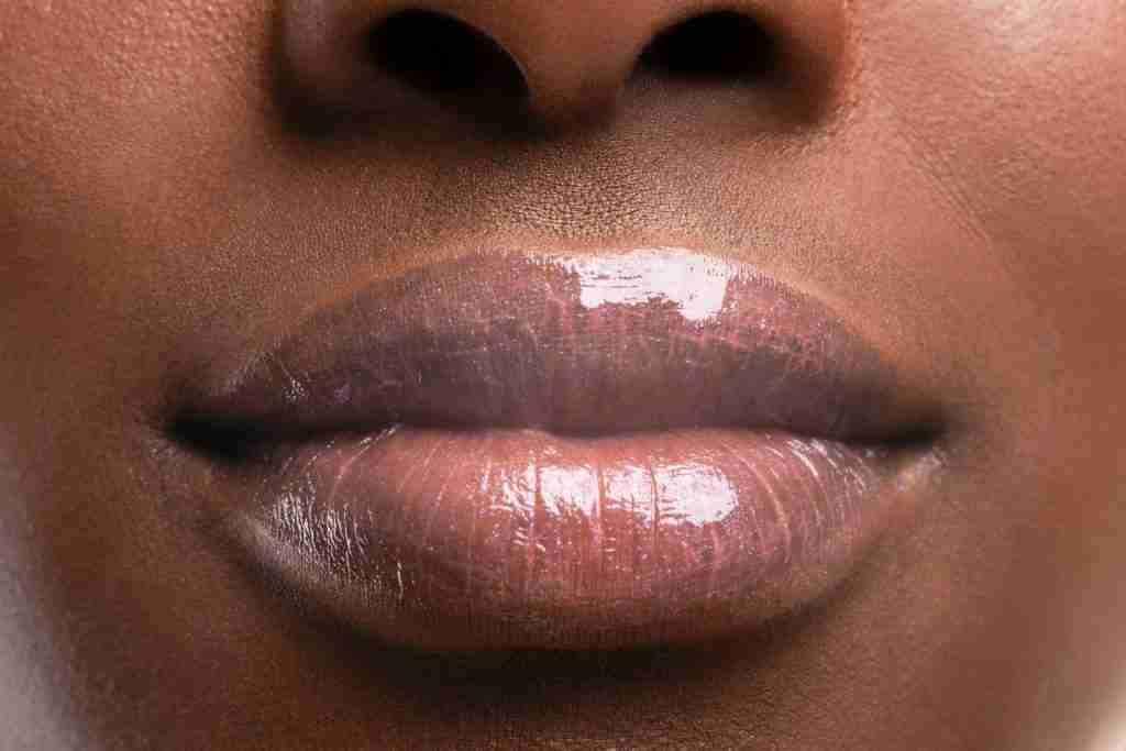up-close of the picture of a black lady with a healthy mouth and glistening nude lips