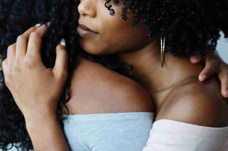 Two black ladies whose face are not clearly seen hugging each other depicting how family and friends can be a source of mental health support