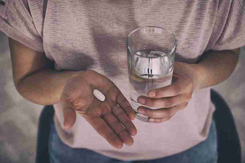 Lady holding a tablet and glass of water worrying about the antidepressant not working