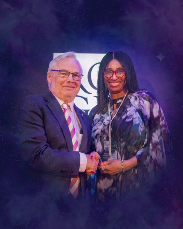 AskAwayHealth Founder Dr Sylvia Kama-Kieghe receives the RCGP 2026 Digital Champion Award, shaking hands with Professor Sir Sam Everington OBE, President of the RCGP, against a purple-lit backdrop.